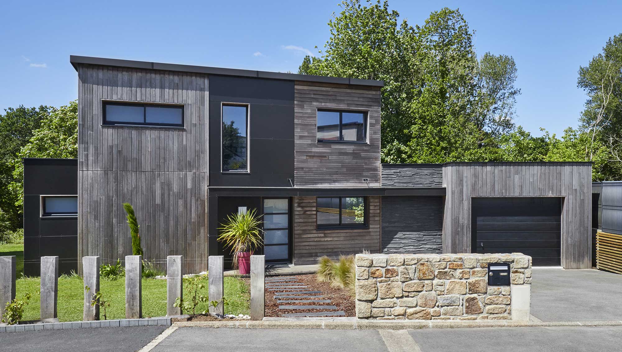 Maison à étage au bardage bois et toit plat