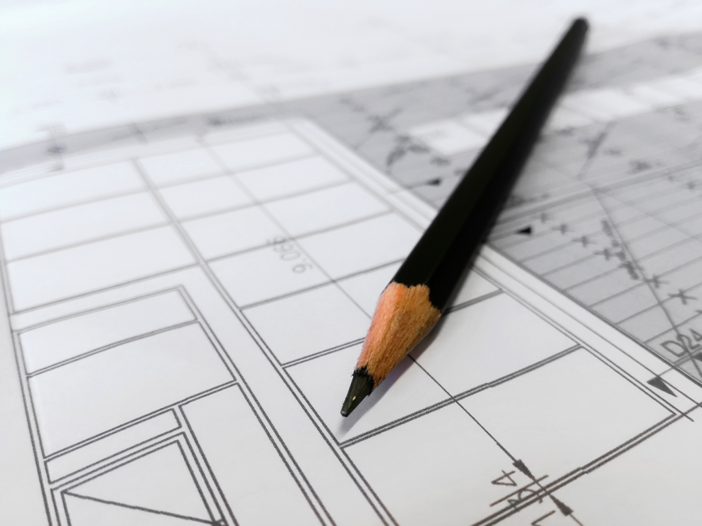 crayon posé sur la maquette d'une maison